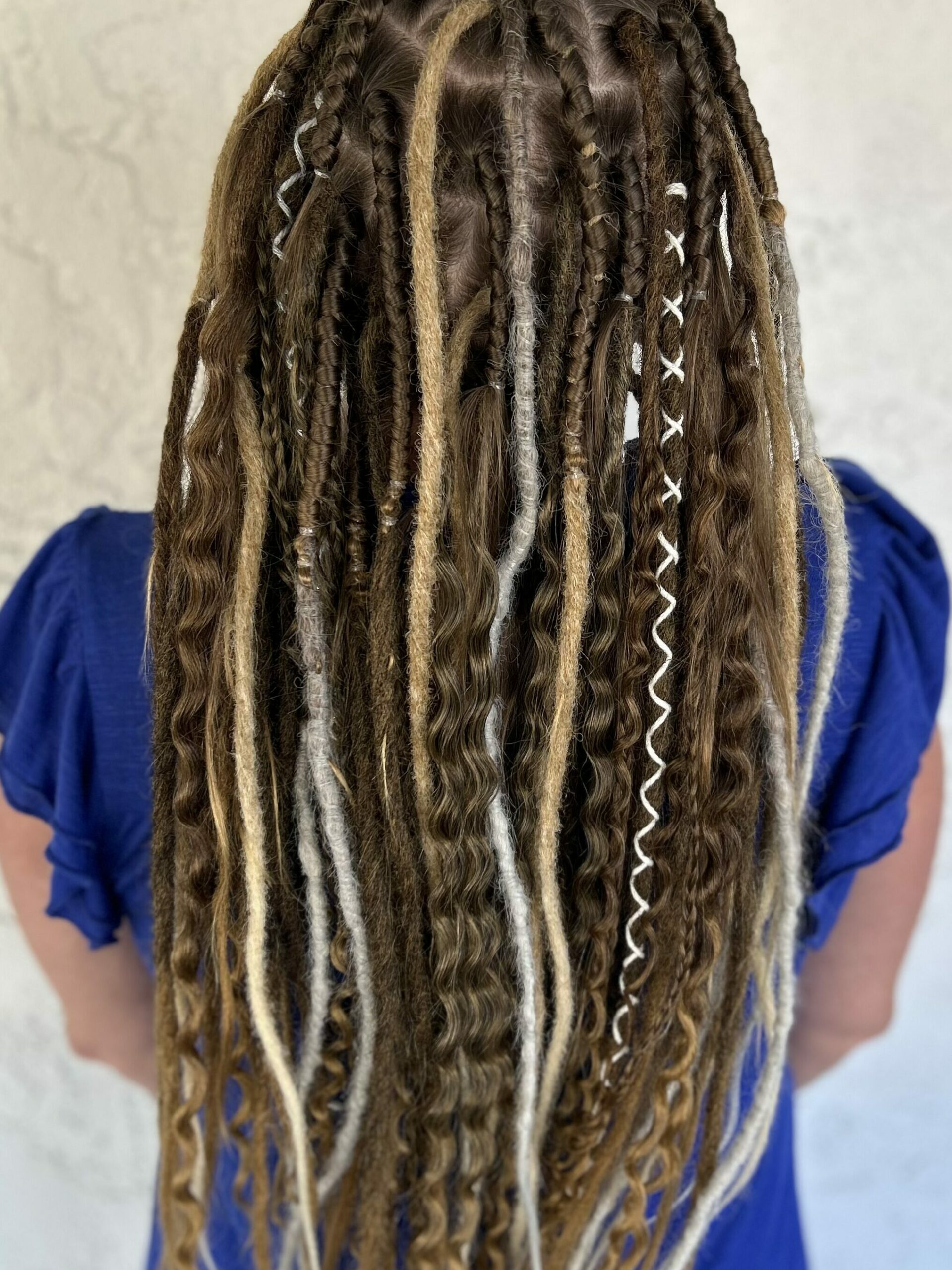 A full, temporary dreadlock installation created with synthetic and wool dreadlock extensions.