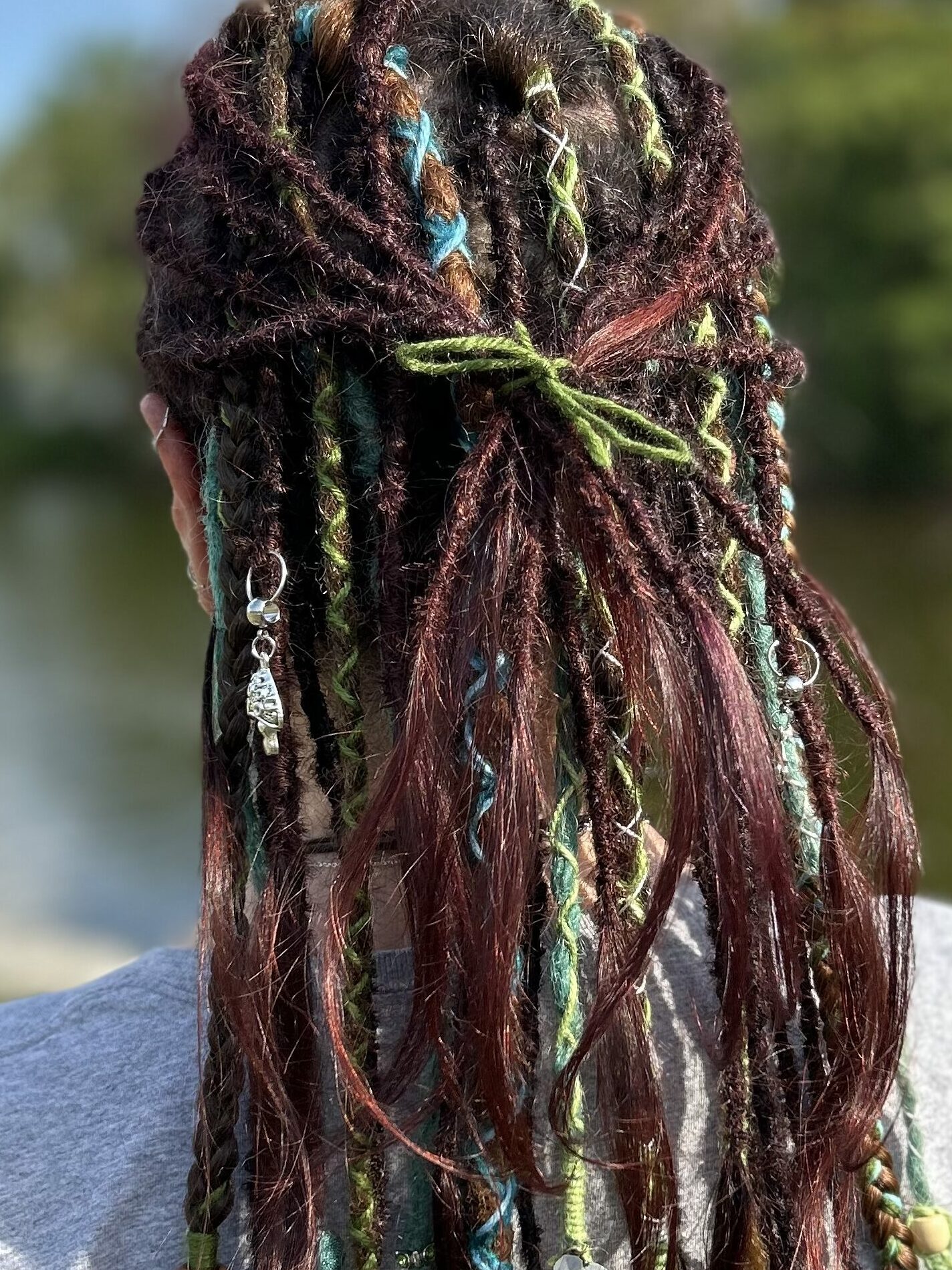 A full head of natural dreadlocks decorated with synthetic dreadlock and synthetic braids.